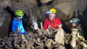 Zkušený jeskyňář Ondřej stojí modelem, aby mladí jeskyňáři rozšířili hliněný skanzen v útrobách Netopýří jeskyně o správnou sošku foto (c) Zbyněk